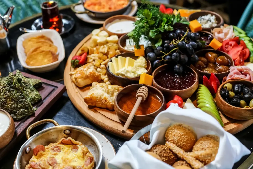 Große Frühstücksplatte von NAR Catering: Bunte Auswahl an frischen Trauben, Nüssen, Konfitüren, süßem veganen Sirup und pflanzlichem Fingerfood