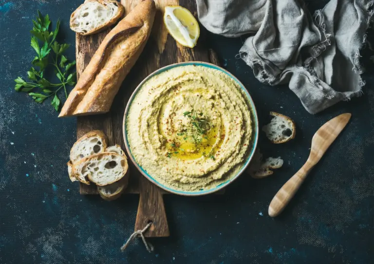 NAR Kitchen veganes Catering: Cremiger Kichererbsen-Hummus nach traditionellem Rezept, perfekt angerichtet mit Zitrone und frischem Brot