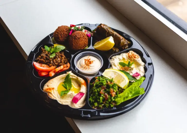 Mediterranes veganes Catering: Buntes Arrangement aus cremigem Hummus, Oliven, Pistazien und gefüllten Minipaprika von NAR Kitchen