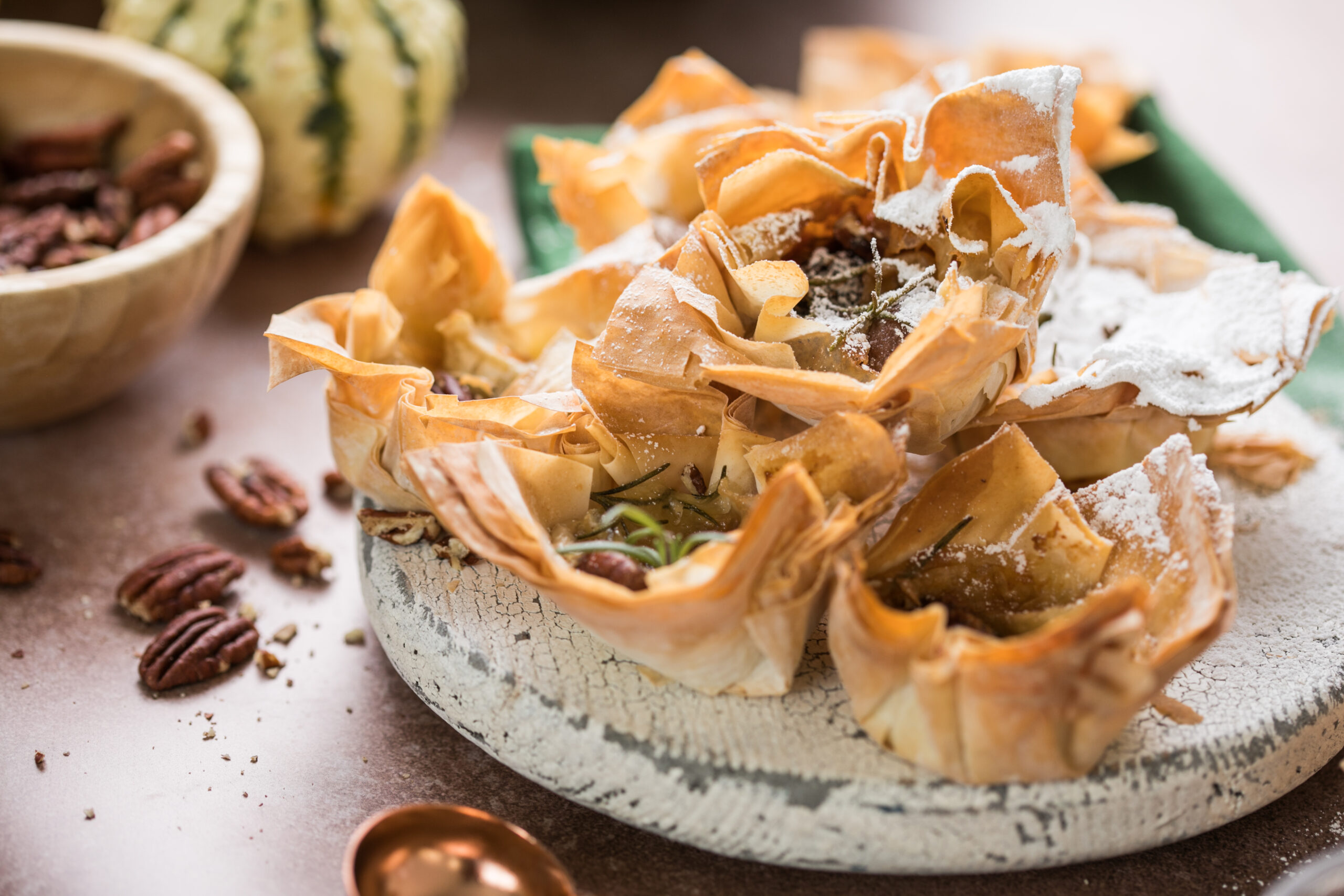 Pflanzliches Dessert-Highlight: Cremige Cheesecake-Füllung trifft auf knusprige Baklava-Elemente und gehobelte Mandeln – kreiert von NAR Catering